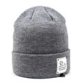 Detail of grey knitted beanie featuring thick vertical ribs and white logo brand label - One Size / Gray