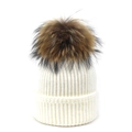 Close-up of white ribbed knit beanie featuring a large brown raccoon fur pom-pom detail - White / One Size