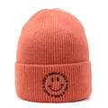 Detailed view of the orange ribbed knit beanie featuring a black smile embroidery - Deep Pink