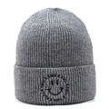 Macro detail of gray knitted beanie showing textured thick yarn and smile embroidery - Gray