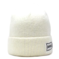 Dettaglio del berretto bianco in maglia a coste con toppa logo ADEK sul bordo risvoltato - Taglia unica / Bianco