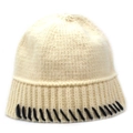 Close-up of knit beanie featuring creamy white fabric with black decorative seam details - Beige