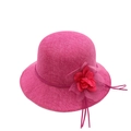 Détail de la texture d'un chapeau de soleil rose en paille avec grande fleur rouge - Rose rouge