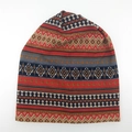 Close-up of knit winter beanie featuring ethnic geometric jacquard patterns and textures - Orange