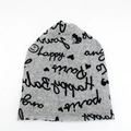 Light gray knit beanie hat with black hand-drawn letter prints and decorative patterns - Gray