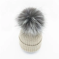 Beige gerippte Strickmütze mit einem flauschigen grauen Kunstfellbommel für den Winter - Beige