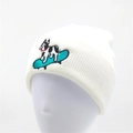 White ribbed knit beanie for women featuring a colorful embroidery of a dog on a skateboard - White