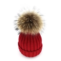 Close-up of chunky dark red knit beanie with fluffy faux fur pom-pom and thick folded cuff - Burgundy