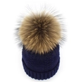 Détail d'un bonnet en tricot bleu marine orné d'un grand pompon en fourrure marron doux - Bleu marine