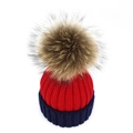 Detailed close-up of a two-tone red and navy blue knit beanie with a fluffy fur pom-pom - Adult / Red + Navy Blue