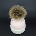 Pink and white knit beanie with a fluffy brown raccoon fur pompom for winter warmth - Pink + White