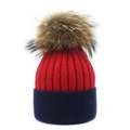 Detail of red and navy blue knitted beanie with a large fluffy faux fur pompom - Red and Navy Blue