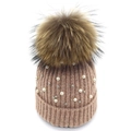 Detailed knit texture of pink winter hat with white pearls and a fluffy pom-pom - Champagne