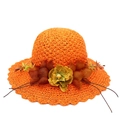 Close-up of bright orange straw sun hat featuring large floral fabric accents and wavy brim - Orange