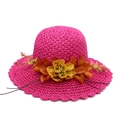 Detailed macro view of vibrant rose red straw sun hat with orange floral accent - Rose Red