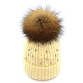 Detailed texture of beige ribbed knit hat with white pearls and a fluffy brown pom pom - Beige