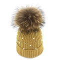 Detail of mustard yellow knit beanie with fluffy fur pompom and pearl accents - Earthy Yellow