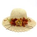Detailed view of the woven straw sun hat with decorative fabric flowers and wavy brim edge - Khaki