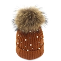 Detail of caramel knit beanie featuring fluffy fur pompom and pearl bead embellishments - Caramel color