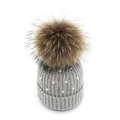 Detailed view of grey knit beanie with fluffy fur pompom and delicate pearl embellishments - Light Gray