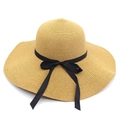Detail of yellow wide brim straw hat featuring a chic black ribbon bow for summer shade - Khaki