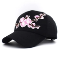 Close-up of detailed pink flower embroidery on a classic black cotton baseball cap - Adjustable / Black