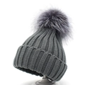 Close-up of thick ribbed knit texture and large fluffy faux fur pompom on grey winter hat - Dark Gray