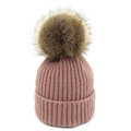 Détail du bonnet en maille côtelée rose poudré avec un grand pompon en fausse fourrure douce - Rose