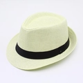 Detail of the breathable woven texture and black ribbon on a classic beige fedora straw hat - Beige