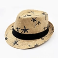 Dettaglio di un cappello di paglia fedora con stampe di palme nere e nastro decorativo - caffè