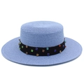 Détail d'un chapeau de paille bleu clair avec ruban noir et strass colorés - Rose bonbon