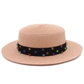 Détail de la texture d'un chapeau de paille rose avec ruban noir orné de gemmes - Rose Clair