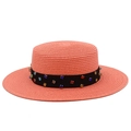 Détail d'un chapeau canotier rose avec ruban en satin noir et strass multicolores - Rose