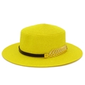 Detail view of the black ribbon band and golden leaf accent on the yellow straw hat - Yellow