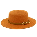 Close-up of orange straw boater hat with brown leather belt and golden metal buckle - Caramel color