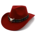 Détail d'un chapeau de cowboy en laine rouge avec bande ethnique et ornement de crâne de taureau - Bordeaux
