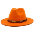 Detail of orange wool fedora featuring a golden metal feather charm and woven band decoration - Orange