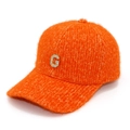 Detail of orange fuzzy knit baseball cap with rhinestone letter G emblem close-up - Orange