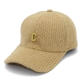 Detailansicht der Strick-Basecap mit goldenem Metall-C-Logo auf beigem Gewebe - Khaki