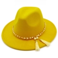 Detail of yellow wool fedora hat featuring gold chain, white pearl, and leather tassels - Yellow