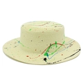 Detailed macro view of beige boater hat showing woven straw texture and vibrant paint splatters - Beige
