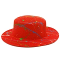 Detailed macro view of red straw Panama hat featuring colorful artistic paint splatters - Red