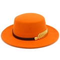 Detailed macro of orange felt fedora featuring a black leather band and gold feather pin - Orange