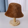 Close-up of brown plush bucket hat on wooden stand showing thick faux fur texture - Dark Brown