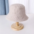 Textura detallada del gorro de lana de cordero beige en un soporte de madera - Caqui
