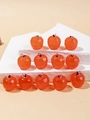 Vue détaillée de 12 pendentifs pomme orange avec crochets argentés sur marches - Prune Rouge