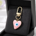 Porte-clés cœur rose avec œil bleu et boucle dorée dans un coffret cadeau noir - Rose