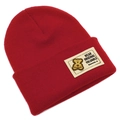 Détail du bonnet en maille rouge foncé montrant la texture côtelée et le patch ours - Bordeaux