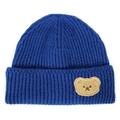 Detailed knit texture of dark blue beanie featuring a cute teddy bear plush patch - Royal Blue