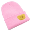 Dettaglio del berretto in maglia rosa con toppa a forma di orso giallo sul risvolto - Taglia unica / Rosa